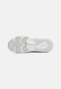 Athletic shoe sole in light gray with textured accents and a wavy design. Features rubber traction patterns for grip and durability.