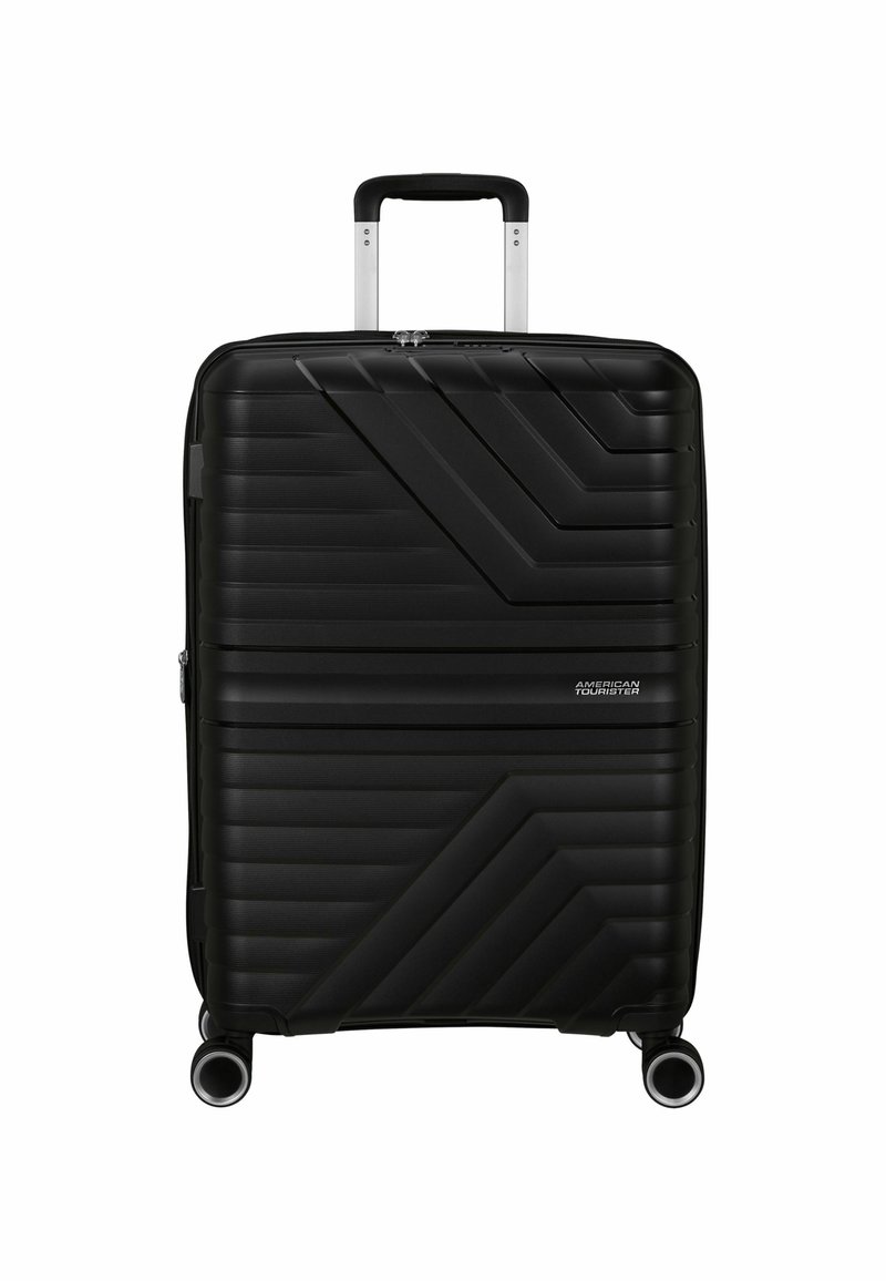 Valigia rigida nera con design a coste diagonali texturizzate, manico retrattile e quattro ruote girevoli. Presente logo del marchio.
