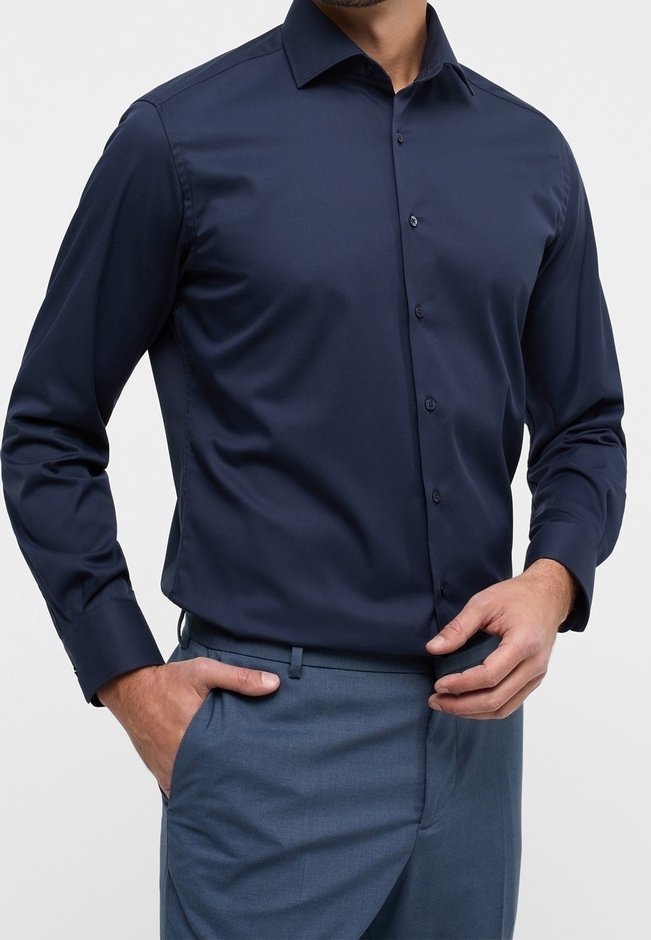 Chemise habillée bleu marine à manches longues avec col, boutons et texture lisse ; assortie à un pantalon bleu clair.