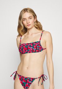 Conjunto de biquíni floral composto por um top cropped com alças finas e uma parte de baixo ajustável com nó. O tecido tem um fundo preto com flores vibrantes em tons de rosa e azul.