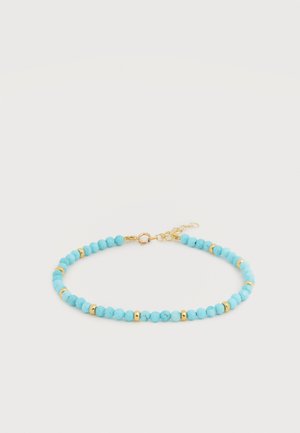 Jemný náramok s malými tyrkysovými korálkami a zlatými oddelovacími korálkami, so zlatým zapínaním a nastaviteľným retiazkou.