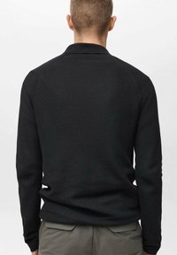 Maglietta polo nera a maniche lunghe con tessuto a maglia testurizzato, dotata di colletto a costine e maniche con polsini, vista da dietro.