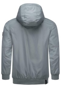 Chaqueta con capucha de color gris claro, con una textura suave y brillante. Presenta puños elásticos, un dobladillo acanalado y un parche de logo discreto en la manga.