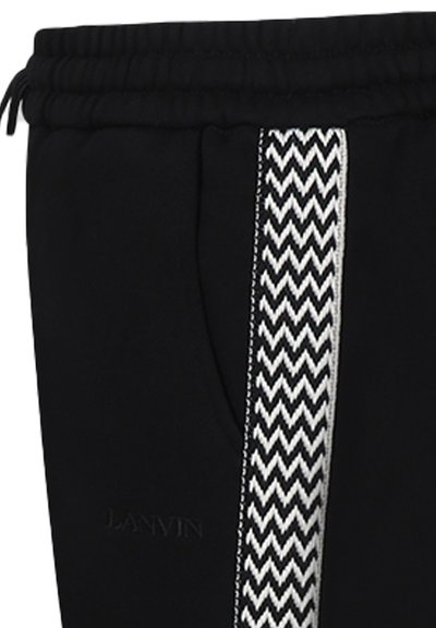 Pantalons de jogging noirs avec une bande latérale à motif zigzag texturé en blanc. Dotés d'une taille élastique et de détails de logo.