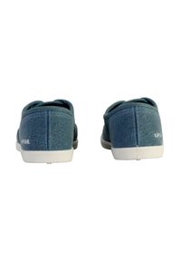 Scarpe slip-on in tela blu con finitura testurizzata, suole in gomma bianche e senza hardware visibile. Design semplice con bordi arrotondati.