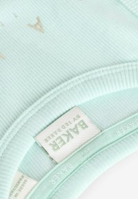 Mintgrön ribbad tyg med en slät textur; har en sydd halsringning och en etikett med "BAKER"-märke och detaljer om design.