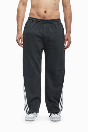 Black sweatpants with white stripe accents on the sides, featuring an elastic waistband and a relaxed fit. Made of soft, comfortable material.