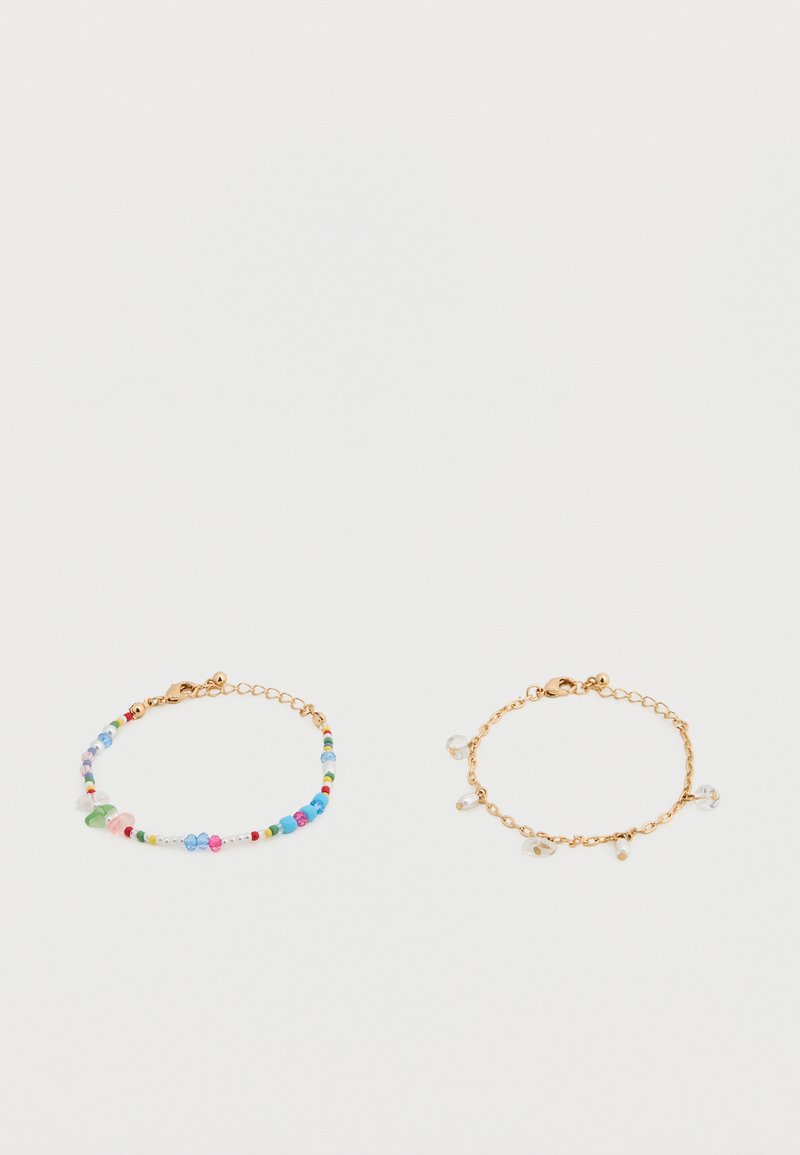 Δύο βραχιόλια: το ένα έχει πολύχρωμες χάντρες και μια χρυσή αλυσίδα· το άλλο διαθέτει απλή χρυσή αλυσίδα με τρεις διάφανες χάντρες ως διακοσμητικά.