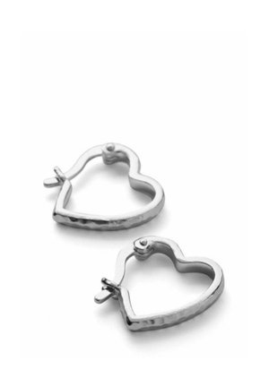 Ezüst szív alakú karika fülbevaló kapcsos zárral fehér háttéren.