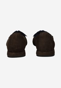 Mocassins en daim marron à profil bas, avec une texture douce et un détail de lacets noirs à l'avant, adaptés pour une tenue décontractée.