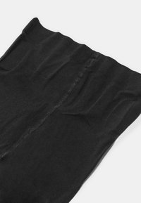 Czarne rajstopy nylonowe o gładkiej fakturze, z bezszwowym pasem w talii i subtelnym połyskiem, leżące na płasko, aby pokazać kształt i detale.