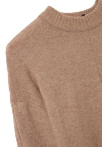 Weicher beiger Strickpullover mit geripptem hohem Kragen und einer detaillierten Nahtführung im Schulter- und Ärmelbereich.
