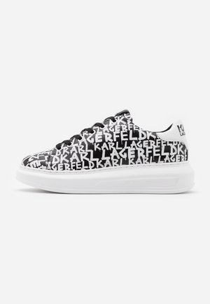 Sort og hvid sneaker med tyk hvid sål og ensartet hvidt "Karl Lagerfeld" tekstmønster, sorte snørebånd og en hvid hælstrop med logo.