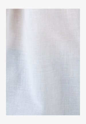 Tessuto bianco leggero e semi-trasparente con trama aperta, appeso con pieghe morbide e dettagli di trama visibili.