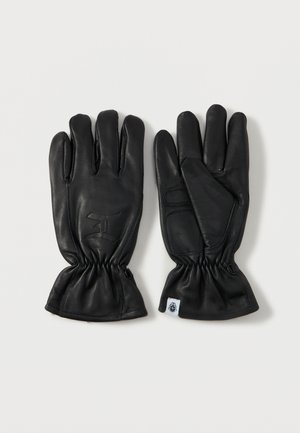Zwarte leren handschoenen met vijf vingers, gerimpelde polsen en een reliëflogo op de achterkant; zachte textuur en gladde afwerking.
