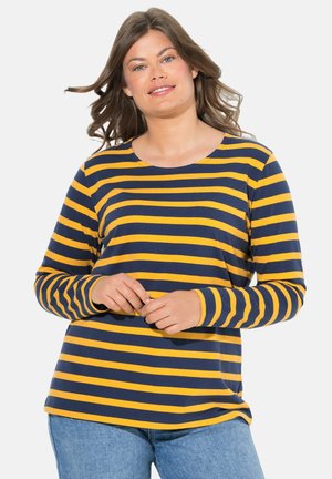 Chemise à manches longues avec des rayures horizontales bleu marine et jaune, col rond, en coton, coupe décontractée, et jean bleu clair.