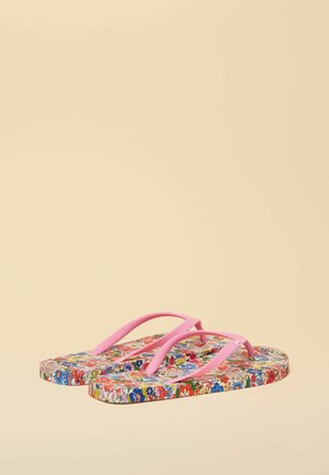 Șlapi cu bretele roz și tălpi cu model floral în roșu, albastru, verde și alb pe un fundal bej.