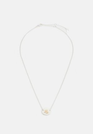 Zilveren ketting met een kleine ronde hanger met een goudkleurig "M" en "L" monogram op een witte achtergrond.