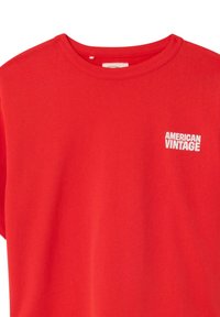 T-shirt rouge à col rond avec le logo texte blanc "AMERICAN VINTAGE" sur le côté gauche de la poitrine.
