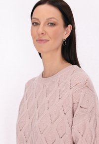 Hellrosa gestrickter Pullover mit Rautenmuster, rundem Ausschnitt und leicht offener Strickstruktur an den Ärmeln.