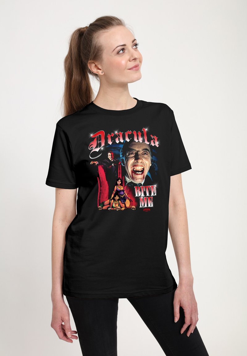 Svart t-shirt med en färgglad grafik av Dracula och en kvinna, med texten "Dracula BITE ME" i fet röda bokstäver.