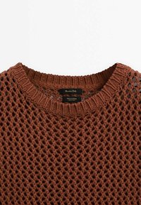 Maglione in cotone marrone lavorato a maglia con design a rete e scollo a costine. Etichetta visibile all'interno, che indica il materiale e il marchio.