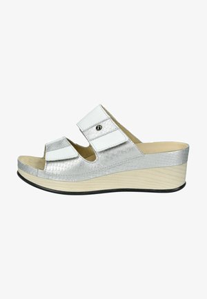 Sandalo platform argento con texture rettile, ampie cinghie bianche, punta aperta e tacco a cuneo leggero. Suola nera e dettagli decorativi.