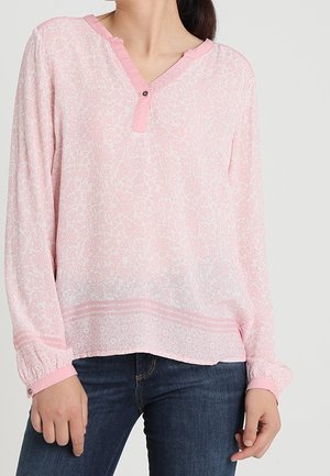 Blouse à motifs roses avec un col henley, des détails de boutons, des manches longues avec des poignets élastiques et une coupe légèrement large.