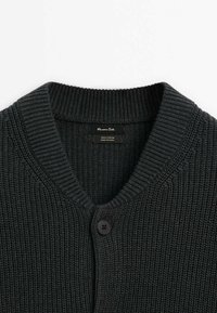 Cardigan en coton tricoté épais gris foncé avec col en V côtelé et un seul bouton noir au centre devant.