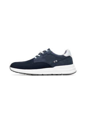 Zapatilla deportiva azul marino con parte superior de malla texturizada, suela blanca, acentos plateados y diseño con cordones. Cuenta con cuello y lengüeta acolchados.
