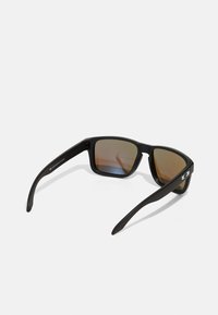 Ochelari de soare negri, rectangulari, cu lentile maro colorate, finisaj mat și punți subțiri care prezintă un accent metalic la tâmple.