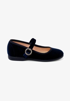 Chaussure Mary Jane en velours bleu marine avec un bout arrondi, une semelle plate et un accent décoratif en boucle ronde. Comprend une bride sur le cou-de-pied.
