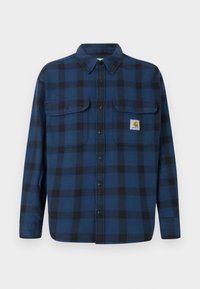 Μπλε και μαύρο καρό φανέλα με μακριά μανίκια, κουμπιά μπροστά, δύο τσέπες στο στήθος και ετικέτα μάρκας στην αριστερή τσέπη.