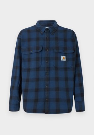 Μπλε και μαύρο καρό φανέλα με μακριά μανίκια, κουμπιά μπροστά, δύο τσέπες στο στήθος και ετικέτα μάρκας στην αριστερή τσέπη.