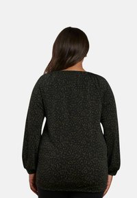 Långärmad topp i mörkgrön med ett abstrakt svart mönster, med lös passform, rund halsringning och rynkade ärmar.