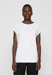 Weißes T-Shirt mit kurzen Ärmeln, rundem Ausschnitt und umgeschlagenen Ärmeln, aus weichem Baumwollstoff gefertigt. Verfügt über einen lässigen Schnitt und nahtlose Kanten.