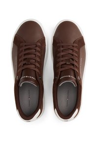 Pair of brown leather and suede sneakers with white soles, brown laces, and Tommy Hilfiger branding on tongues and sides.