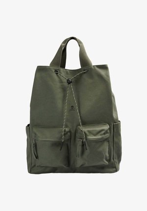 Oliivinvihreä kangasreppu, jossa on kaksi etutaskua vetoketjuilla, kiristysnyöri ja kaksi lyhyttä kantokahvaa.