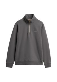 Sudadera gris con cremallera de cuarto y cuello alto, textura suave y puños acanalados. Presenta un pequeño logo en el pecho y un dobladillo recto.