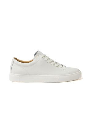 Sneaker in pelle bianca a taglio basso con lacci bianchi, suola piatta in gomma e fodera interna color cuoio mostrata di profilo su sfondo bianco.