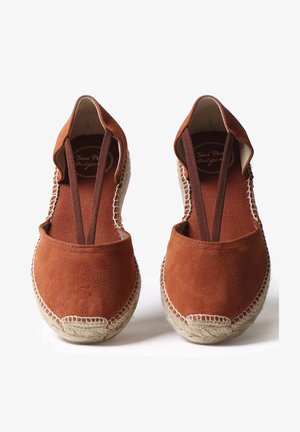 Pár rustikovo zafarbených semišových espadril s pletenými jutikovými podrážkami a elastickými popruhmi cez vrch, zobrazenými z prednej strany.