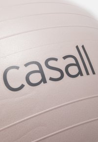 Ružičasta lopta za vježbanje s teksturiranom površinom, koja nosi ime branda "casall" u crnom fontu i horizontalnim žljebovima za bolji zahvat.