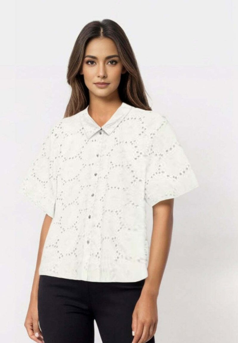 White short-sleeve button-up shirt with a textured fabric featuring eyelet cutouts, rounded collar, and a relaxed fit.