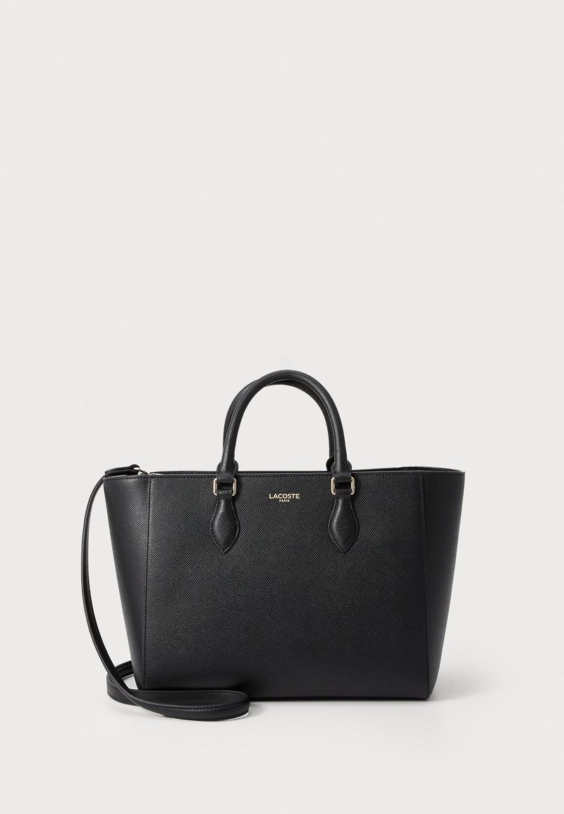 Black tote bag made of textured material, featuring two sturdy handles, a detachable shoulder strap, and a logo accent on the front.