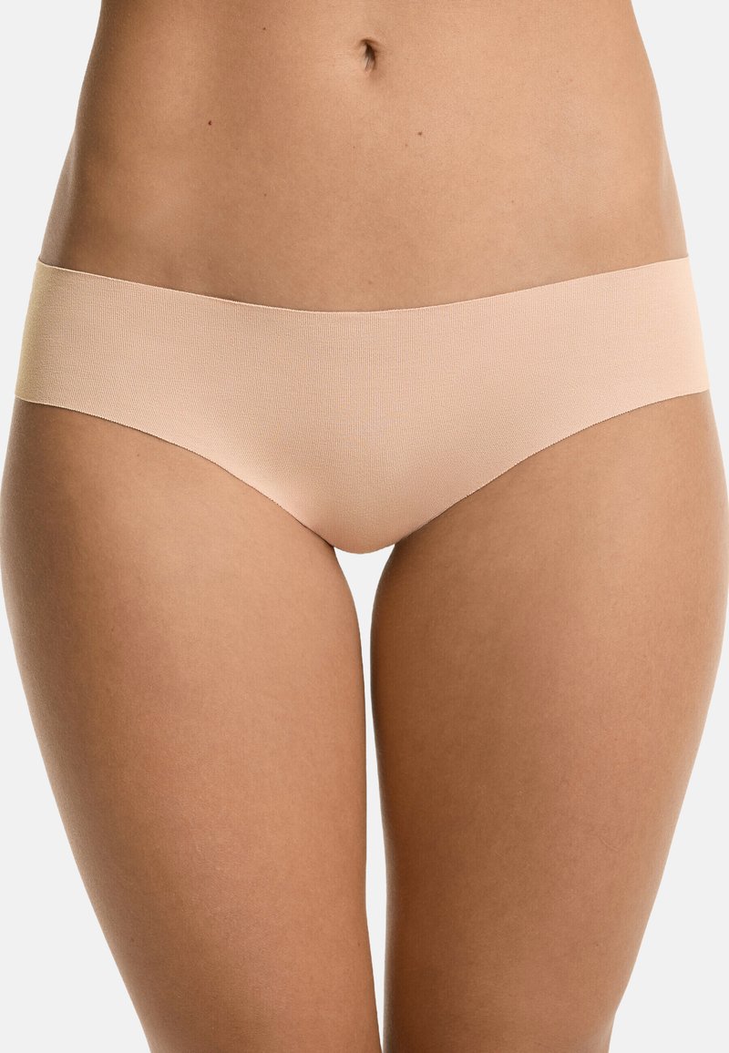 Beige naadloze slip met een gladde textuur en een brede tailleband, ontworpen voor comfort en minimale zichtbaarheid onder kleding.