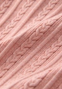 Tissu tricoté rose doux avec des motifs en câble tressé en relief créant une apparence texturée et confortable.