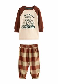 Conjunto infantil de dos piezas en marrón y crema. Camiseta de manga larga con gráfico de cocodrilo y texto; pantalones a cuadros con cintura elástica.