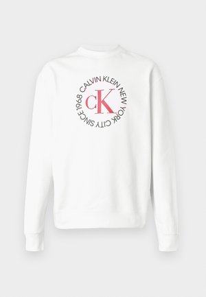 Sudadera blanca de manga larga con cuello redondo y logo CK rojo rodeado de texto negro que dice "Calvin Klein New York City Since 1968" en el frente.