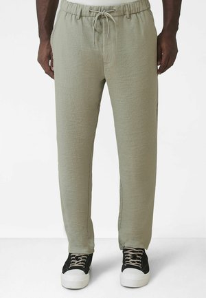 Jasnozielone, casualowe spodnie o teksturowanej tkaninie, z elastycznym pasem i sznurkiem do regulacji. Połączone z czarnymi trampkami z białą podeszwą.