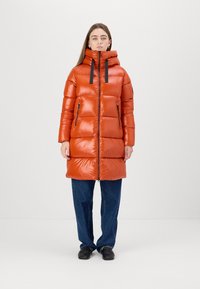 Padded coat in shiny orange material with a zip front, high collar, and black drawstrings. Features two side zippers and a straight cut design.